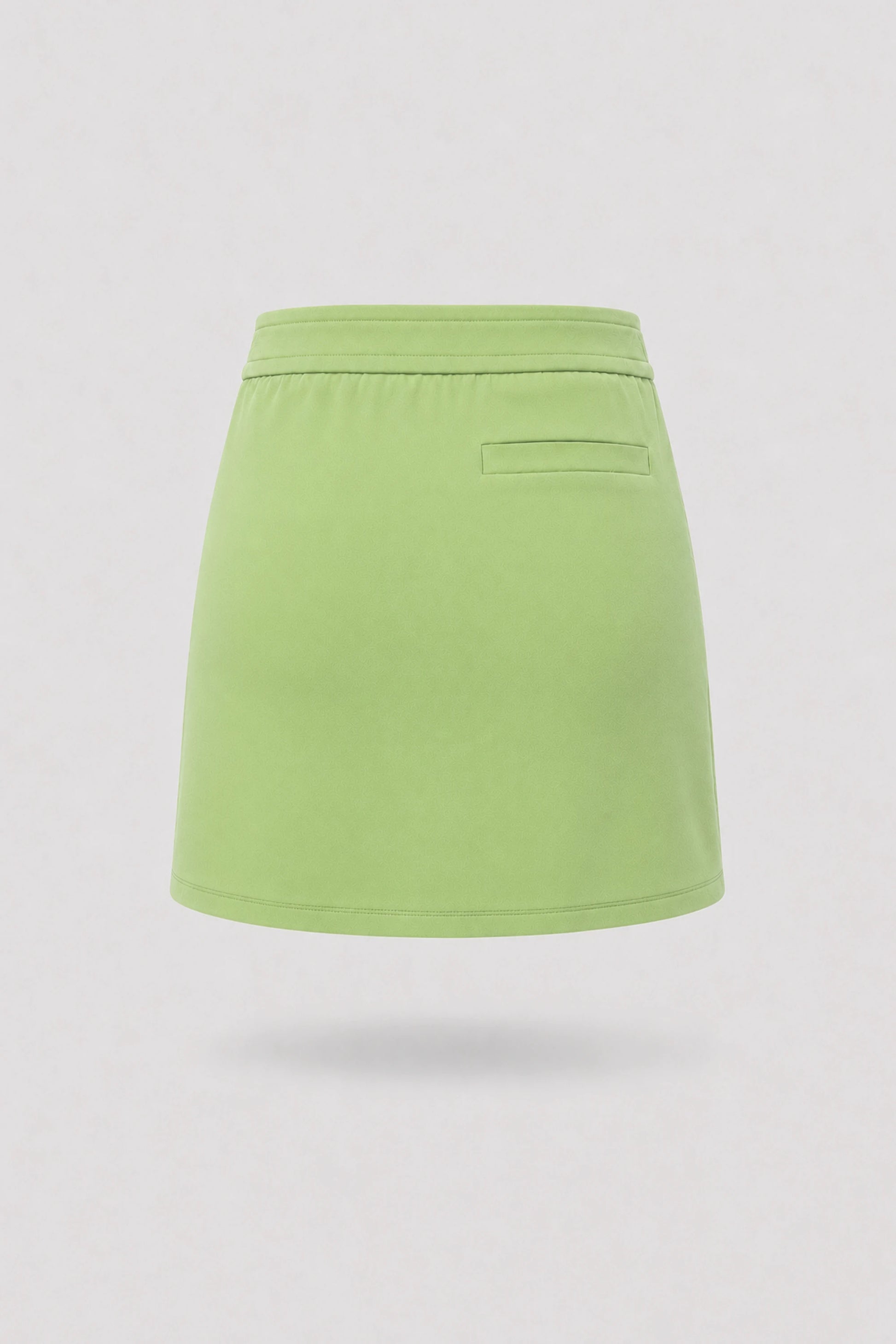 Women's green golf skort back view with clean tailored design and built-in shorts