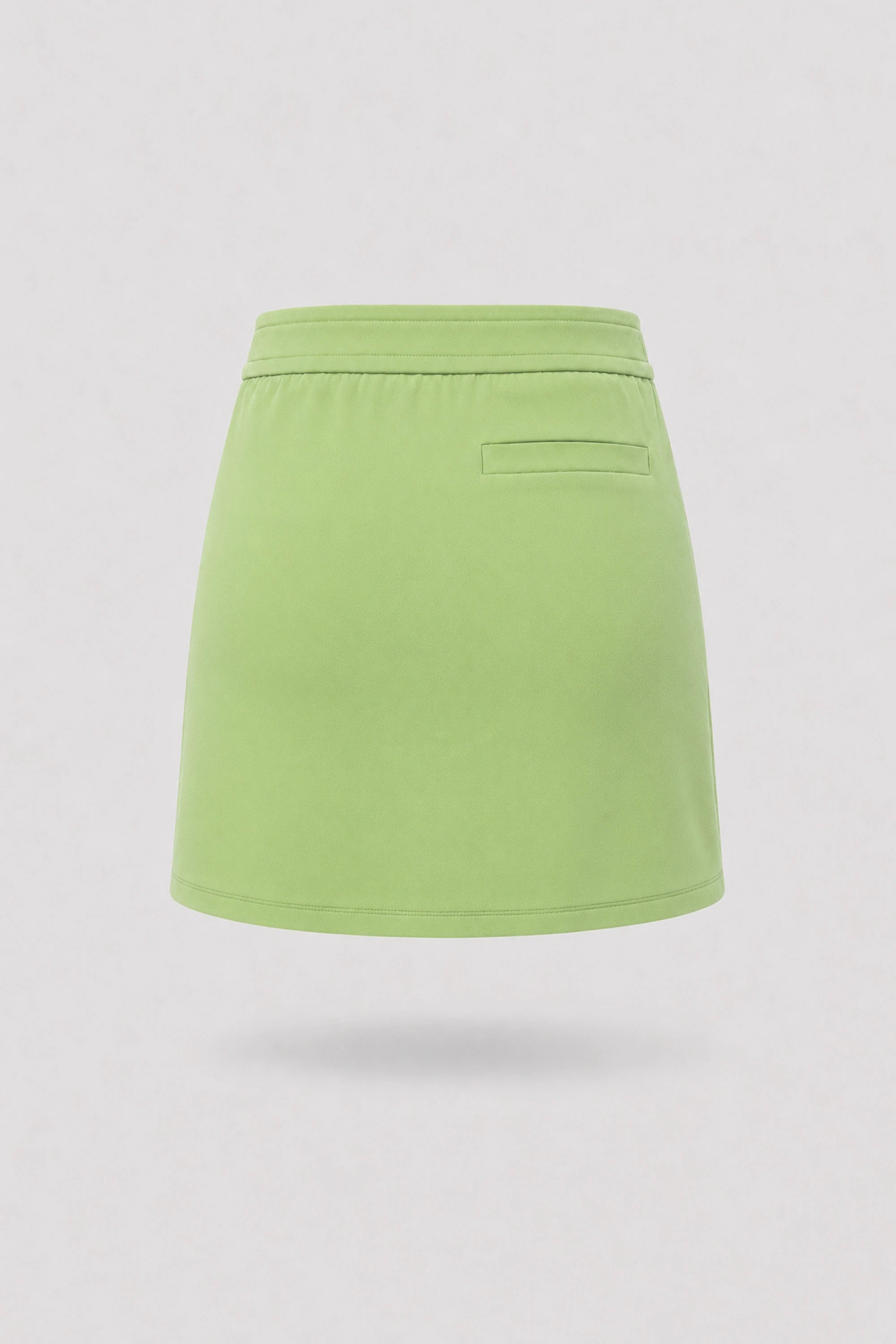 Women's green golf skort back view with clean tailored design and built-in shorts