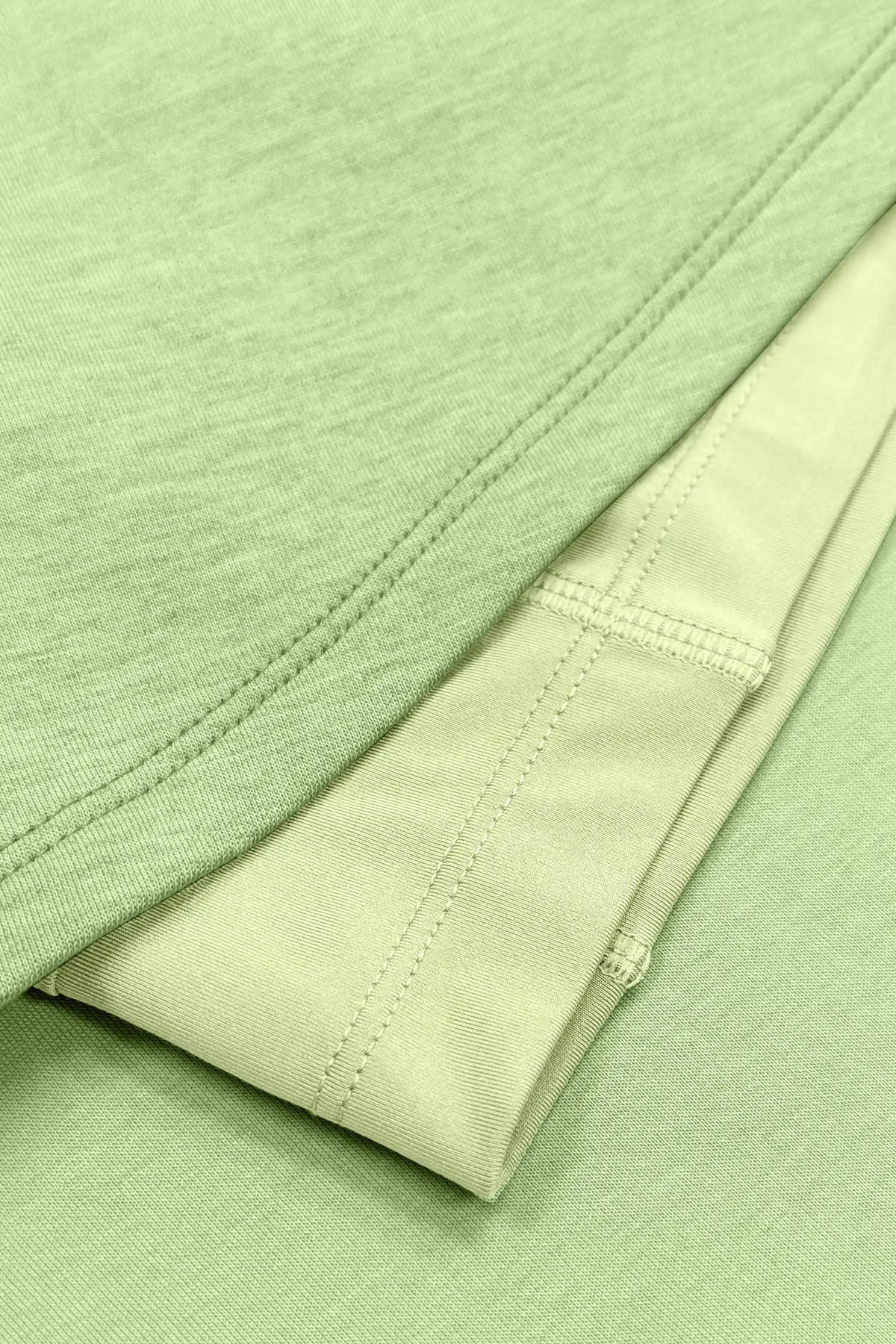 Close-up of the skirt hem stitching and built-in shorts beneath the light green wrap golf skort