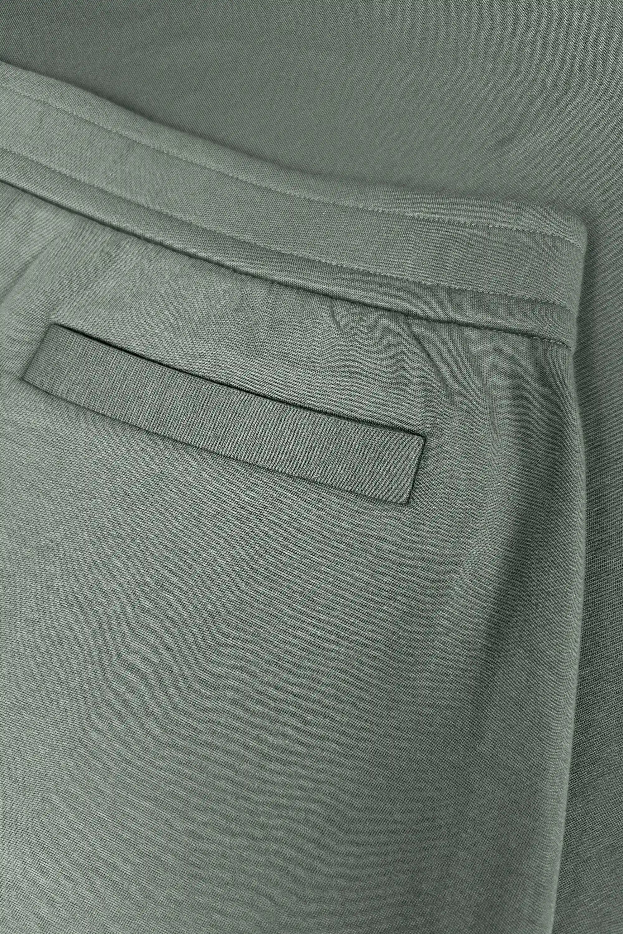Close-up of women’s sage grey wrap golf skort with waistband and welt back pocket detail