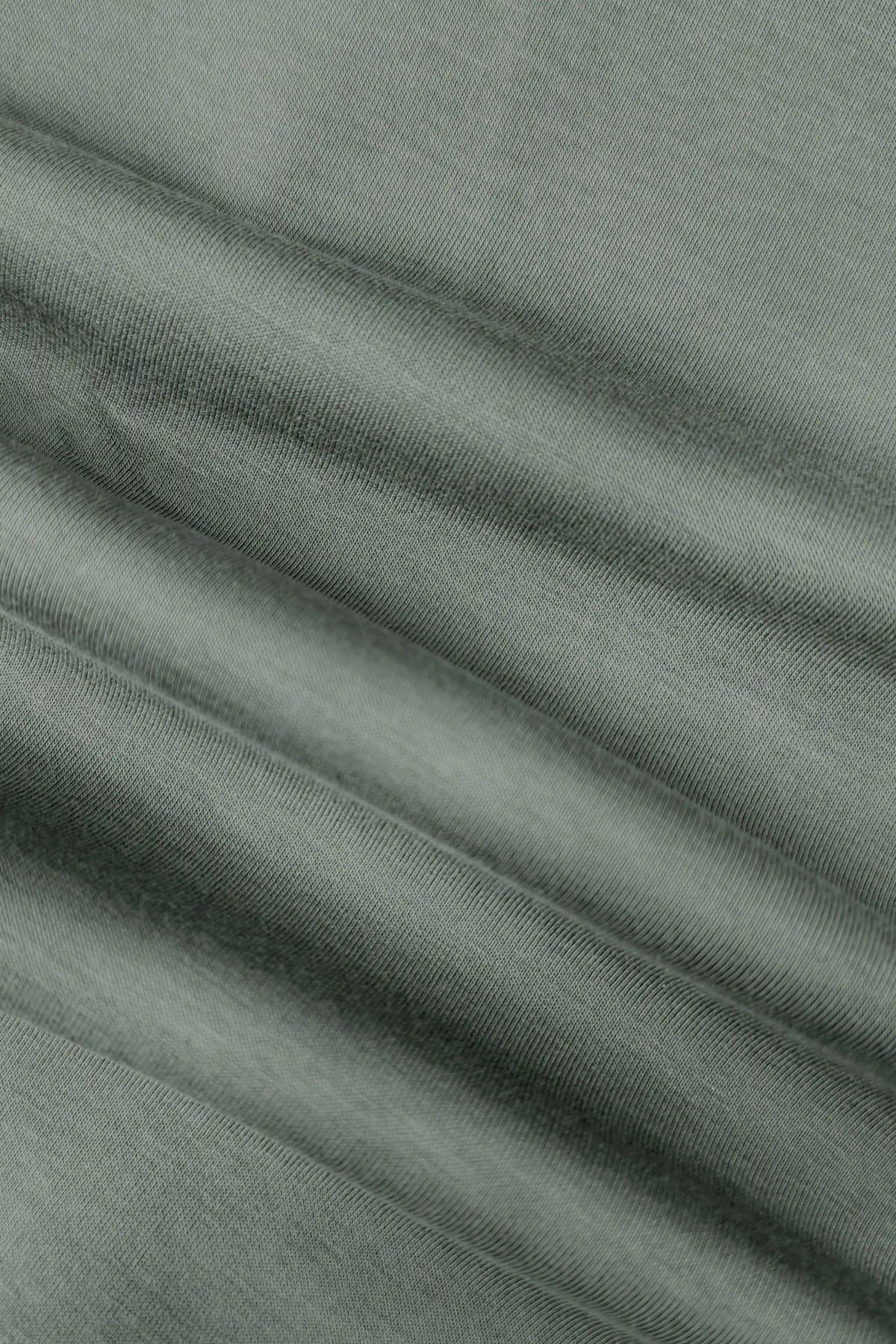 Close-up of the soft stretch fabric texture on the women’s sage grey wrap golf skort