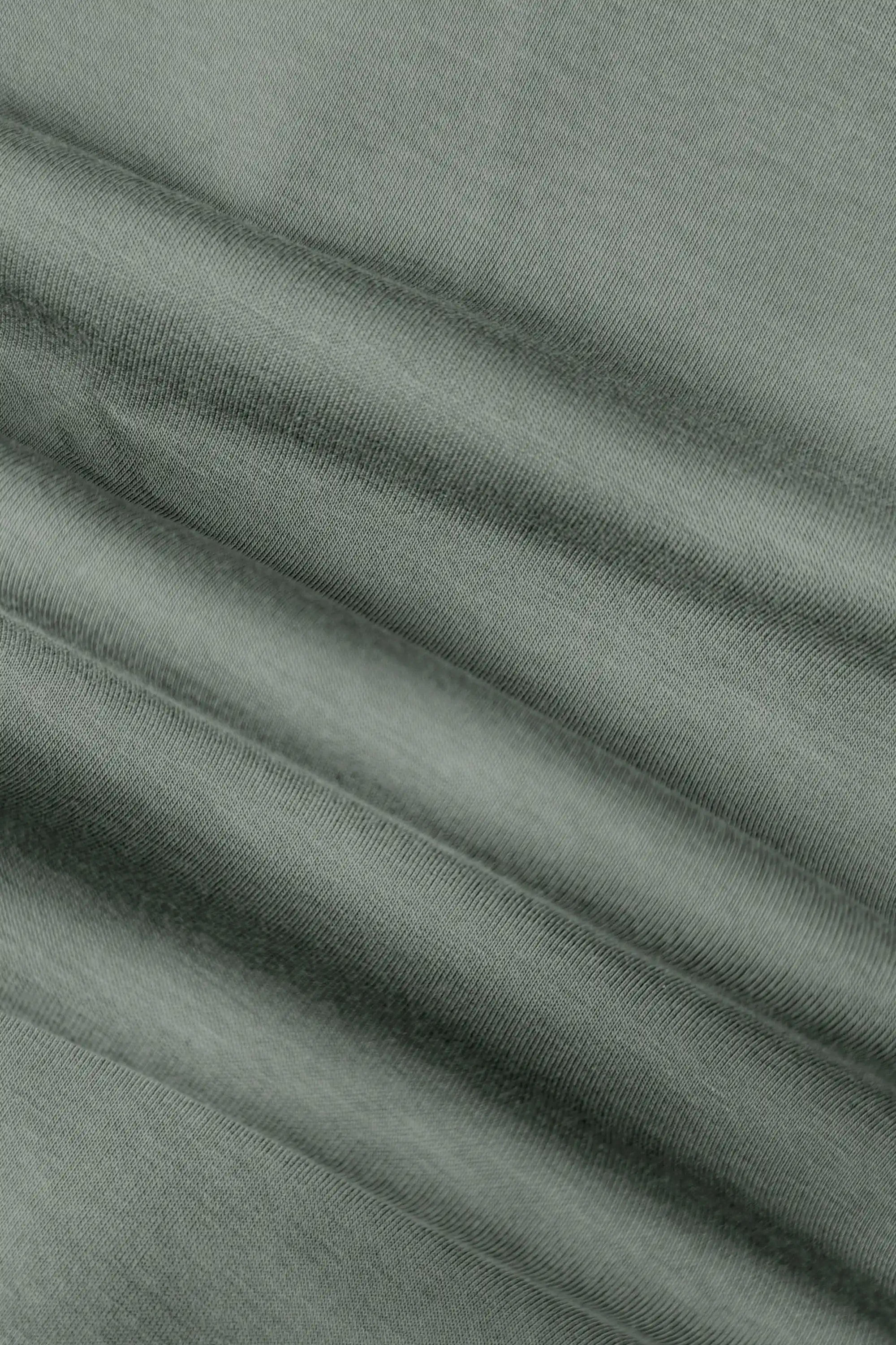 Close-up of the soft stretch fabric texture on the women’s sage grey wrap golf skort