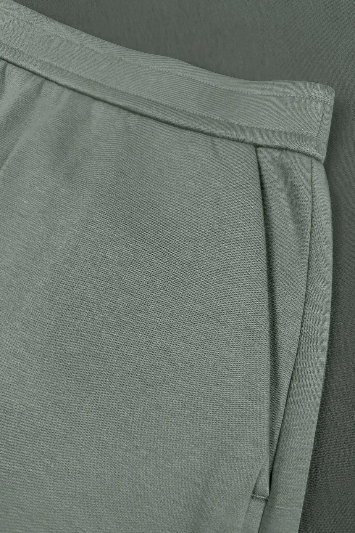 Close-up of women’s sage grey wrap golf skort with structured waistband and side pocket detail