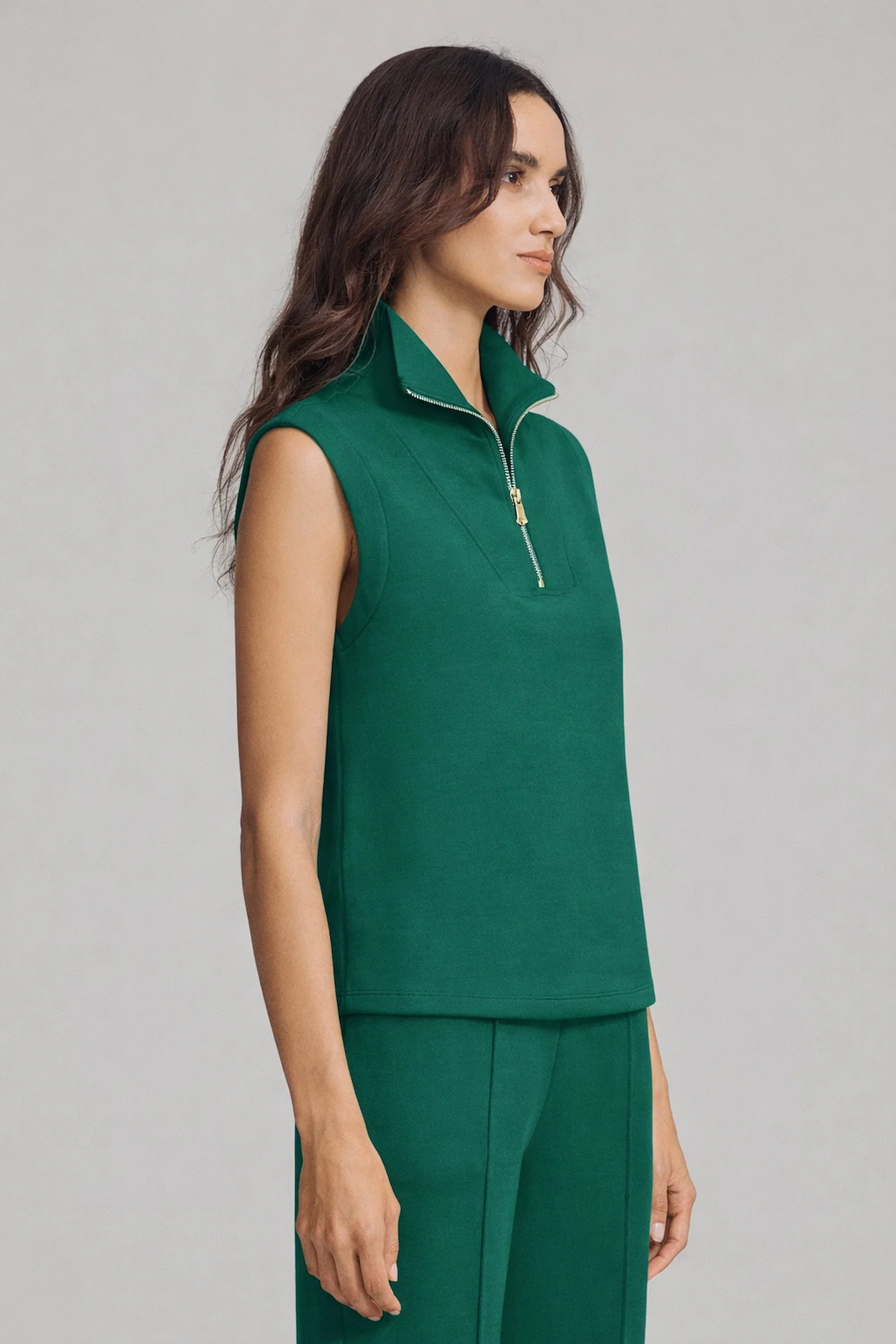 Side profile of women’s sleeveless pullover in deep teal with relaxed tailored fit