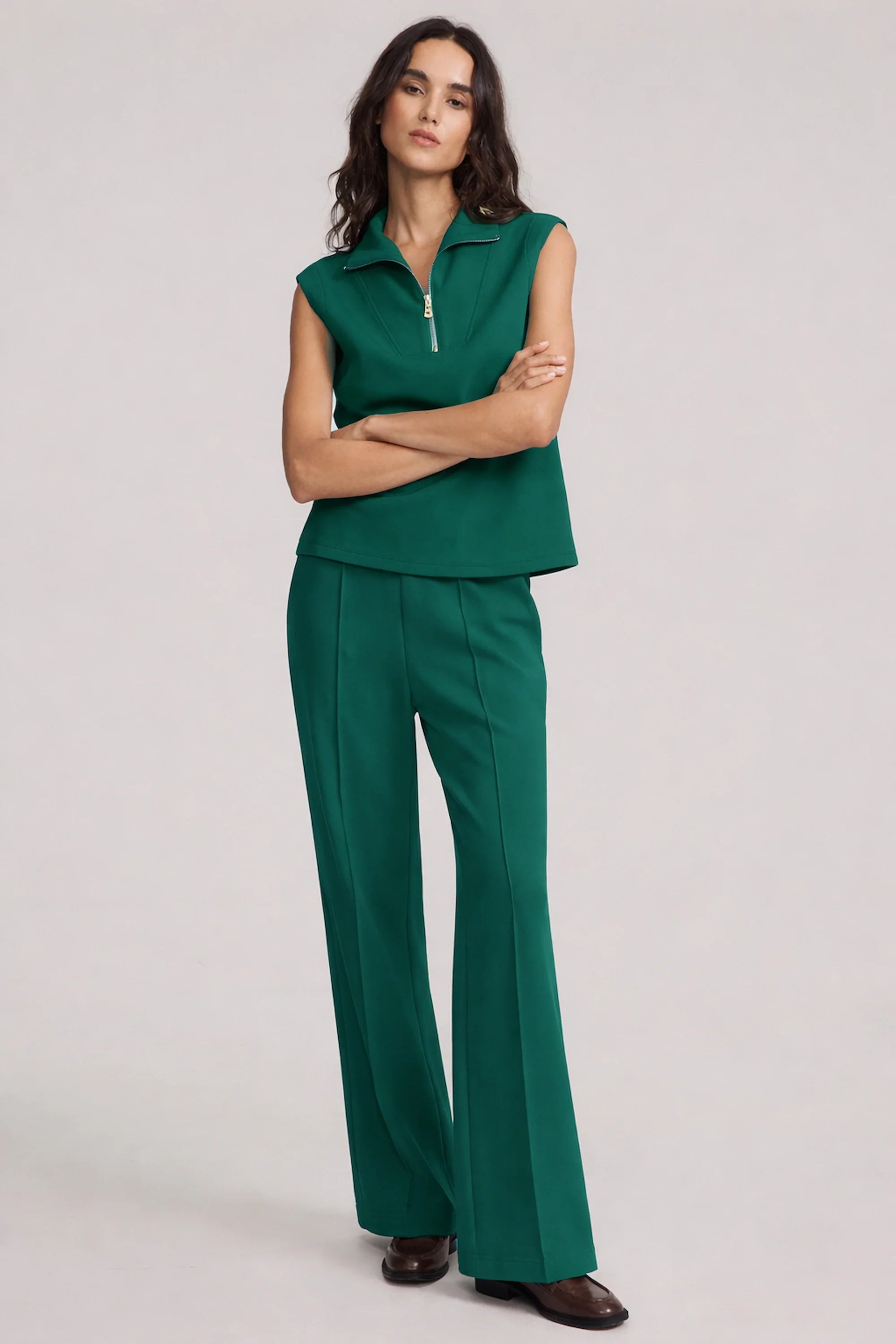 Women’s deep teal sleeveless pullover with structured zip collar and modern silhouette