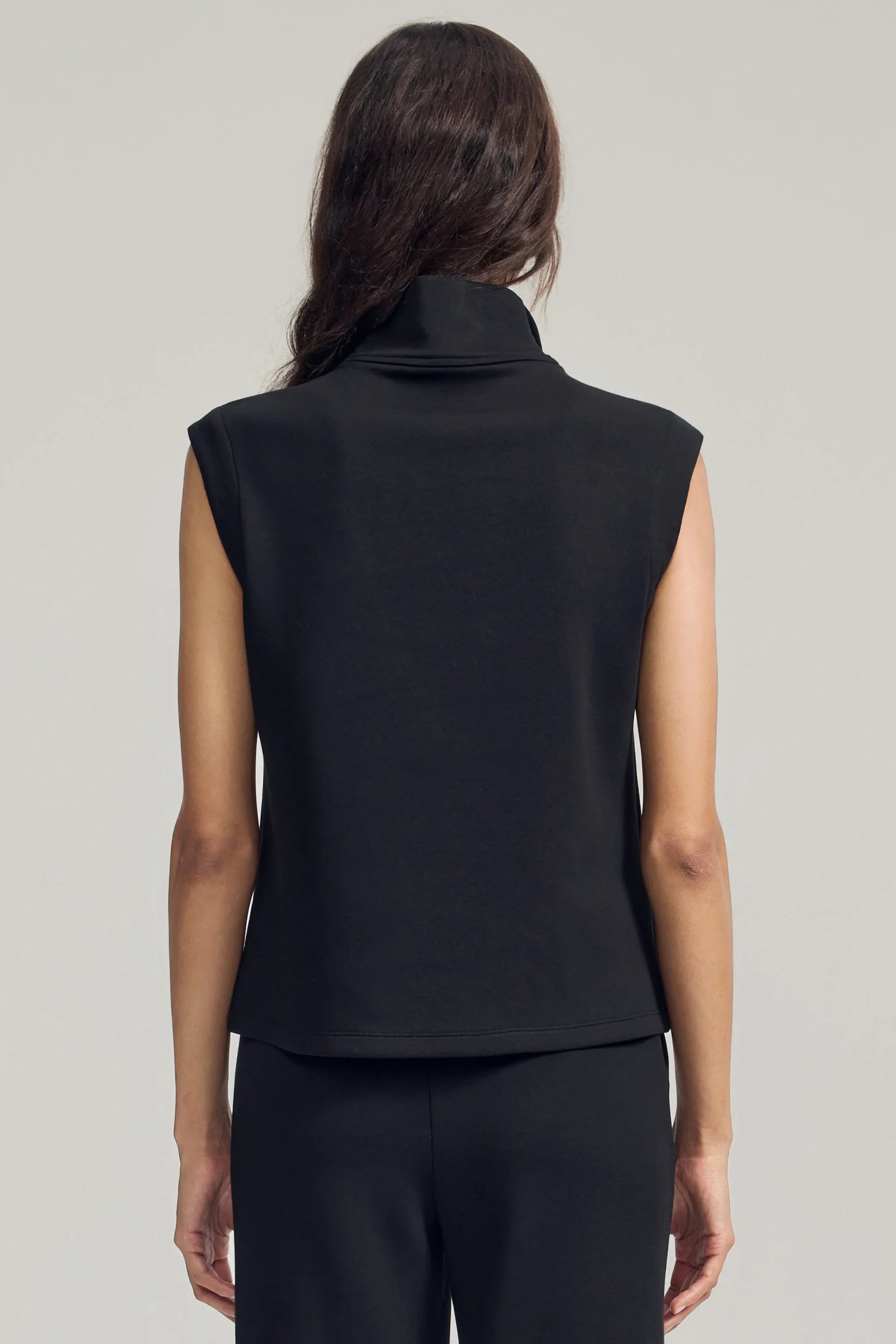 Back view of women’s black sleeveless pullover with clean minimalist silhouette