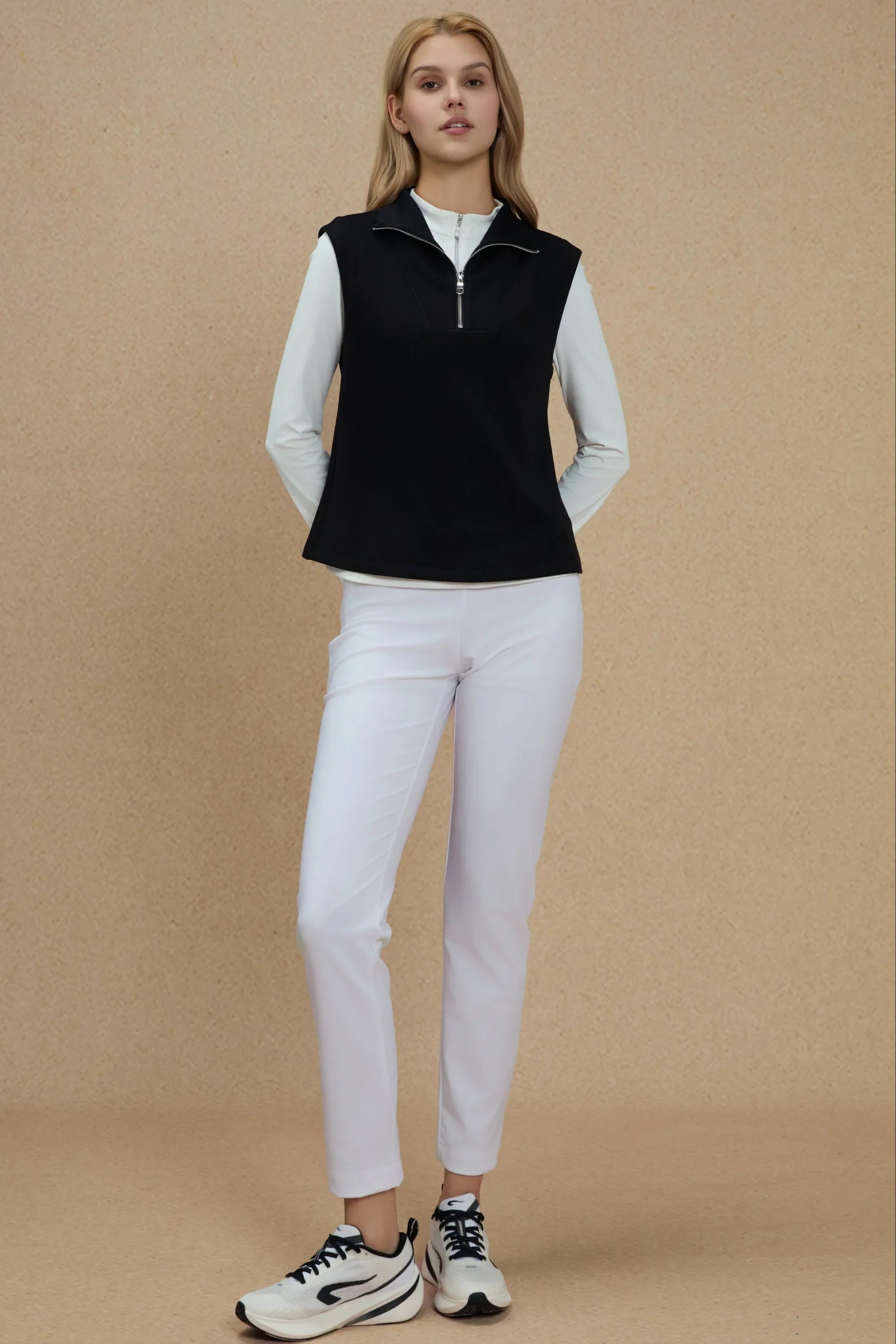 Women’s black sleeveless pullover layered over a white long sleeve top